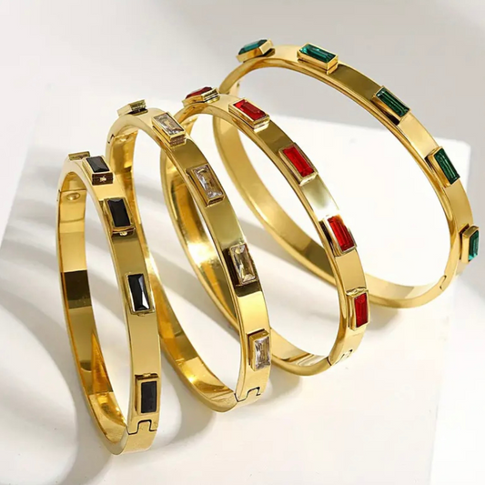 Ruby-Colored Stone Bangle, crafted from durable stainless steel and finished in radiant 18K gold plating. Set with a striking ruby-toned cubic zirconia, this piece delivers classic elegance with the bonus of modern, everyday durability.