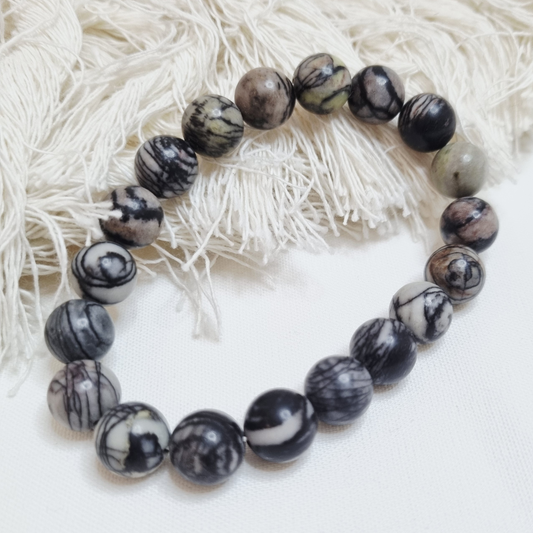 Black and white marbled bead bracelet on a textured white background