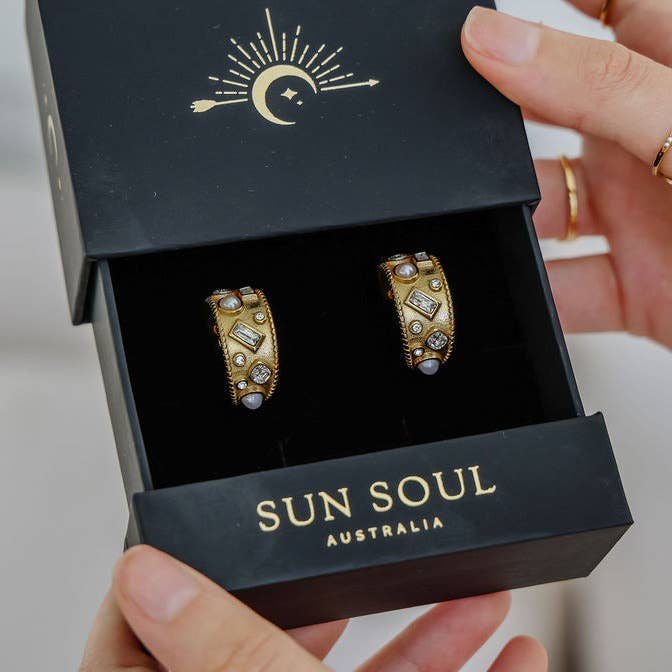 For the bold and effortlessly stylish, the Margot Earrings are here to make a statement. Featuring an elegant crystal and pearl design inlaid within a sculptural feature hoop, these earrings are equal parts refined and daring.
Crafted from hypoallergenic stainless steel and finished with luxurious 18K gold plating, they’re part of our tarnish-free, water-resistant collection—designed to shine through every wear, every time.