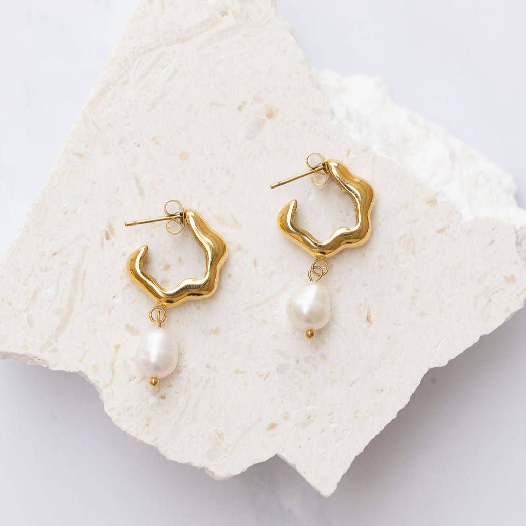 Many mistake her for being preppy and entitled, but make no mistake—Rosie loves to party. Celebrate the bold blend of sophistication and attitude with these unique hoop earrings, featuring a sleek silhouette and an elegant pearl drop charm.
Crafted from hypoallergenic stainless steel with an extra thick 18K gold plating, these earrings are part of our tarnish-free and water-resistant collection—made for women who are as resilient as they are radiant.