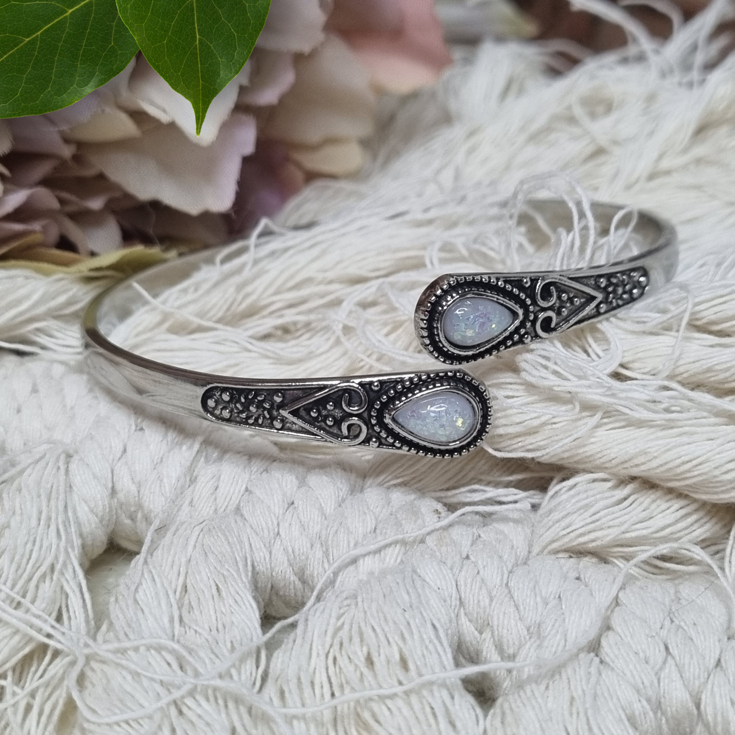 Side view of teardrop opal cuff bracelet showing stone shimmer and etching