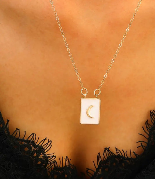 Two gold-plated sterling silver necklaces with vintage tarot card pendants featuring a moon design and a sun design, displayed against a neutral backdrop.