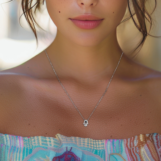 Add some eye-catching charm to your look with our Mini CZ Hand and Eye Necklace in Silver. Featuring a whimsical pairing of a sparkling cubic zirconia eye and a delicate hand charm, this necklace adds a playful touch to any outfit. Whether you're into symbolic jewelry or simply love pieces with personality, this necklace is a subtle conversation starter.
Crafted with a rhodium-plated finish, it’s lightweight, tarnish-resistant, and perfect for everyday wear.