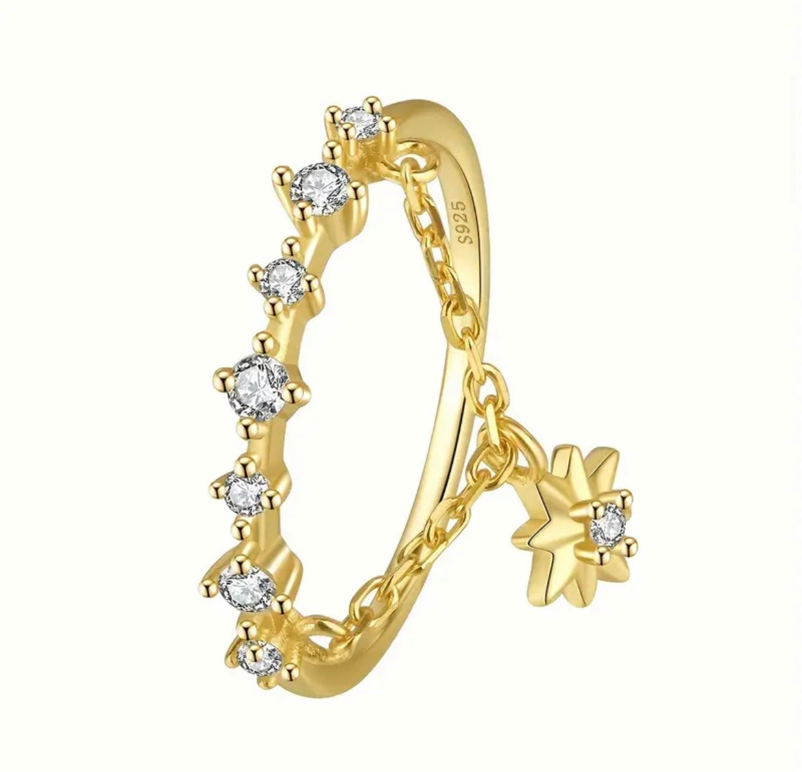 Crafted from 925 sterling silver and plated in rich 18K gold, this ring features a delicate constellation-style band crusted with cubic zirconia, and a dangling star charm for extra movement and shimmer.