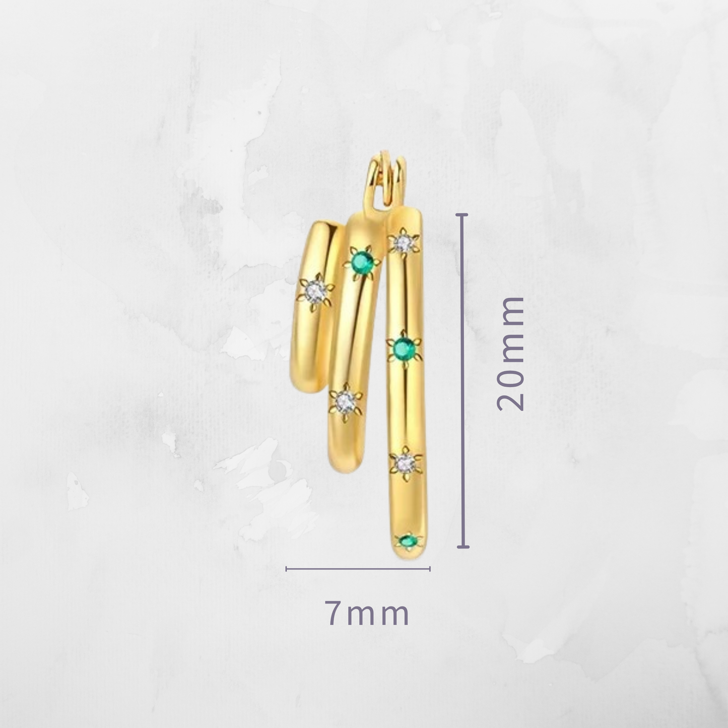 Close-up image of the gold-plated stacked hoop earrings with emerald and CZ stones, shown next to a ruler for size reference.