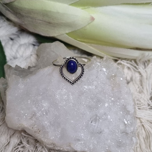 Angled view of lapis lazuli heart ring showing detailed silver craftsmanship and gemstone shine