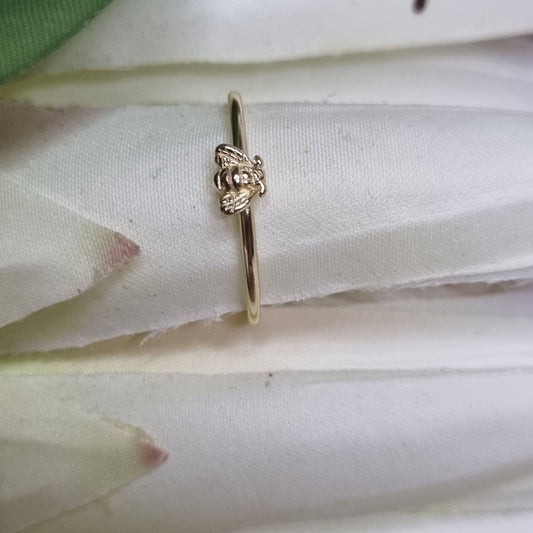 Gold ring with intricate design on a white fabric background
