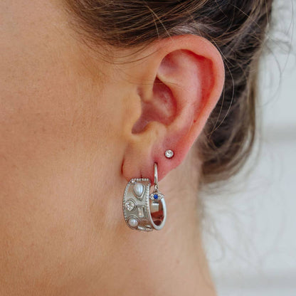For the girl who loves to make a statement, meet the Margot Earrings—a bold yet elegant design featuring a polished feature hoop adorned with inlaid crystals and pearls. The perfect balance of glam and edge, these earrings are made to turn heads without saying a word.

Crafted from hypoallergenic stainless steel and finished in sleek silver, this style is tarnish-free, comfortable to wear, and designed to keep its shine wear after wear.
