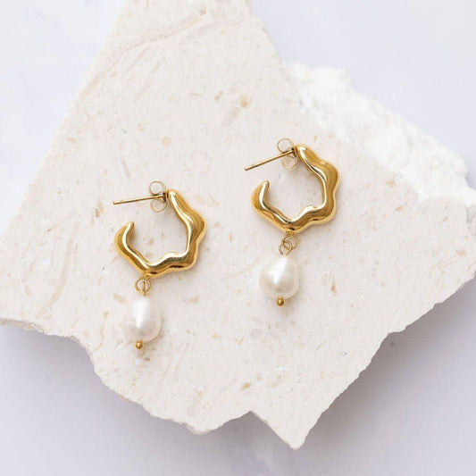 Many mistake her for being preppy and entitled, but make no mistake—Rosie loves to party. Celebrate the bold blend of sophistication and attitude with these unique hoop earrings, featuring a sleek silhouette and an elegant pearl drop charm.

Crafted from hypoallergenic stainless steel with an extra thick 18K gold plating, these earrings are part of our tarnish-free and water-resistant collection—made for women who are as resilient as they are radiant.