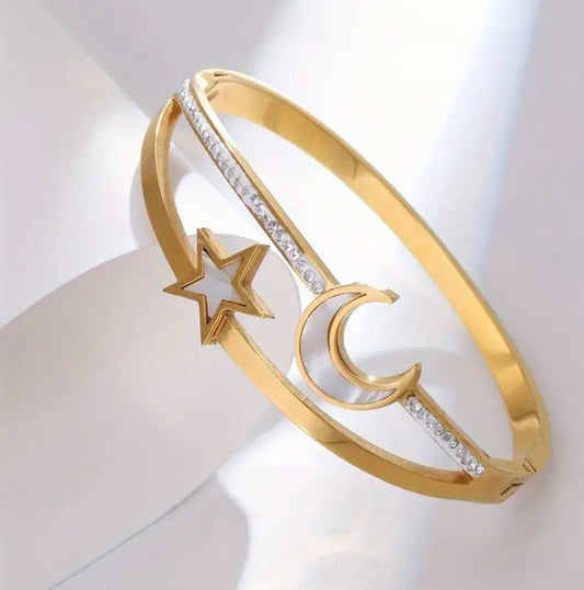 Add a celestial spark to your stack with our Star & Moon Bracelet, crafted from 18K gold-plated stainless steel for a sleek, radiant finish. This durable bangle is waterproof, hypoallergenic, and designed to shine day after day—perfect for layering with your favorite pieces or wearing solo for a subtle cosmic touch.