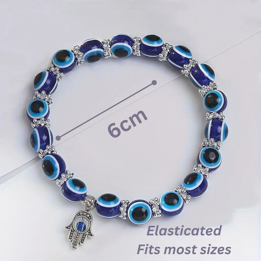 Bracelet with blue and black eye-shaped beads and a Hamsa charm on a white background.