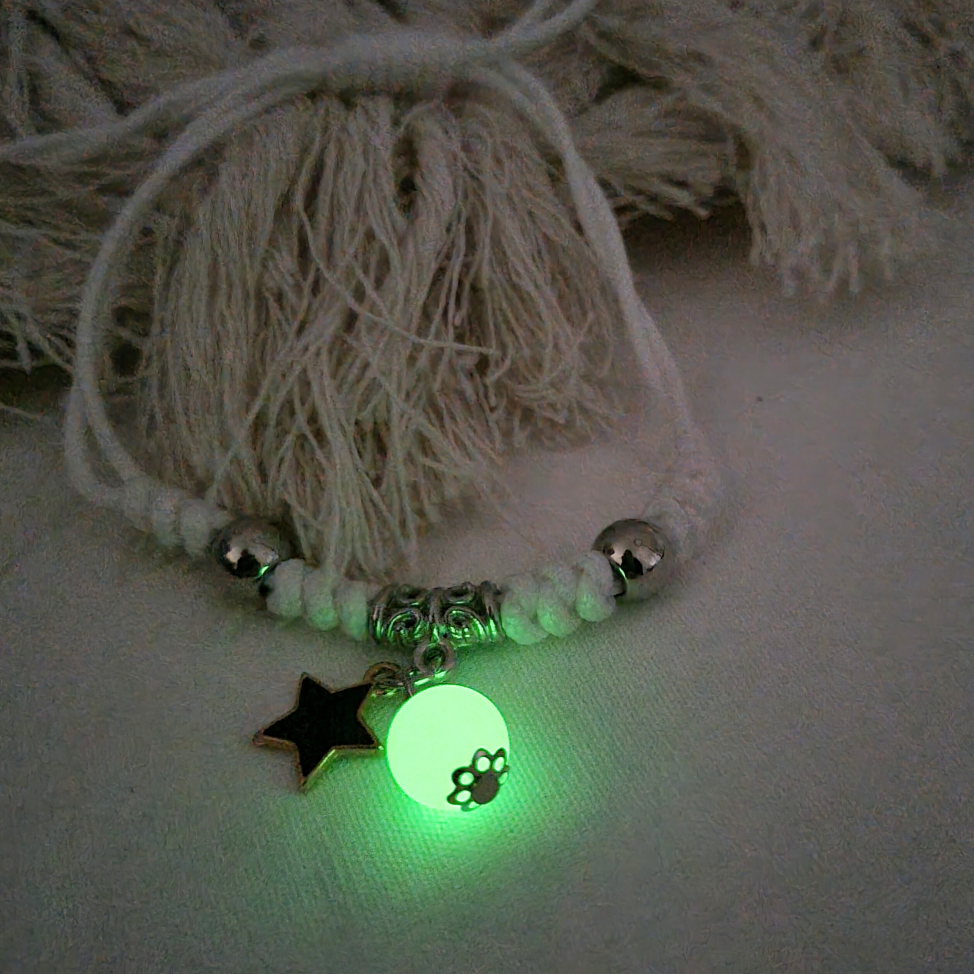 Shine bright with our White Rope Adjustable Bracelet, featuring a bold black star charm and a luminous bead that glows in the dark,