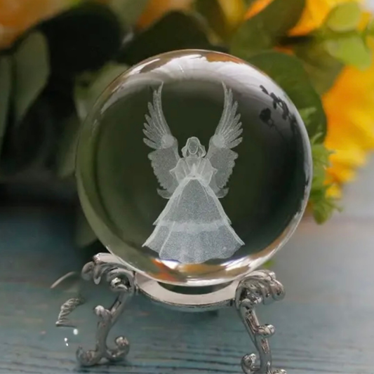 Clear crystal ball with an engraved angel design on a decorative stand.